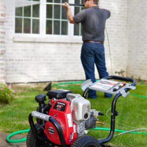 Man cleaning a window using a SIMPSON premium pressure washer